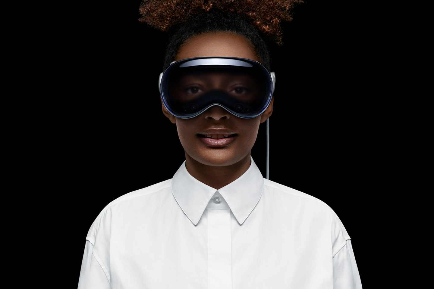 Frau mit Apple Vision Pro Mixed Reality-Brille vor schwarzem Hintergrund